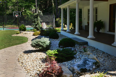 Modelo de jardín clásico grande en patio delantero con entablado