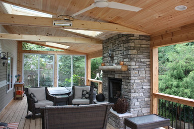 Imagen de terraza tradicional de tamaño medio en patio trasero y anexo de casas con brasero y entablado
