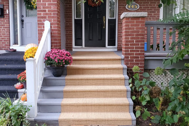 Inspiration for a coastal brick front porch remodel in Toronto