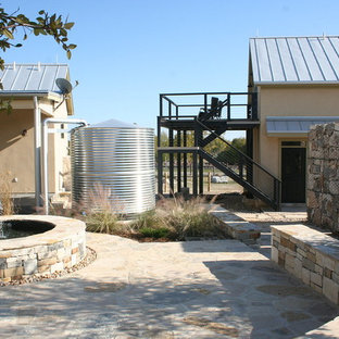 Esempio di un portico industriale dietro casa con fontane e pavimentazioni in pietra naturale