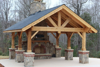 This is an example of a mid-sized rustic concrete back porch design in Charlotte with a fire pit and a pergola.