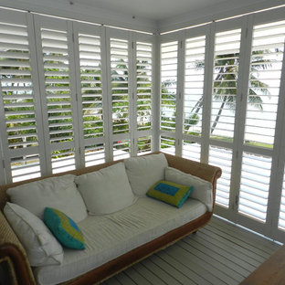 Foto di un piccolo portico tropicale dietro casa con pedane, un tetto a sbalzo e un portico chiuso