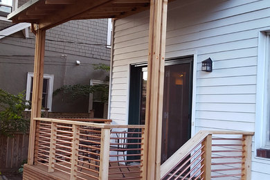 Photo of a large traditional back veranda in Minneapolis with decking and a roof extension.