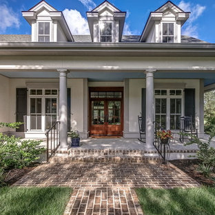 Foto di un grande portico classico davanti casa con cemento stampato e un tetto a sbalzo