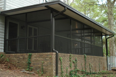 Screened-in back porch photo in Other with an awning