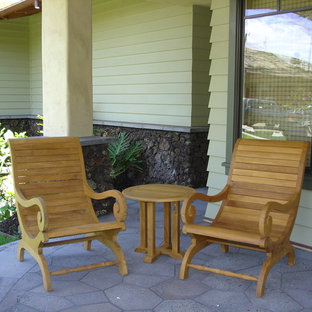 Idee per un piccolo portico tropicale davanti casa con cemento stampato e un tetto a sbalzo