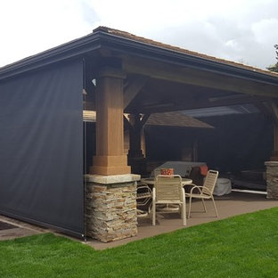Ispirazione per un portico american style dietro casa con lastre di cemento e una pergola