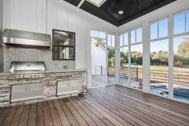 Cette image montre un porche d'entrée de maison arrière avec une cuisine d'été et une extension de toiture.