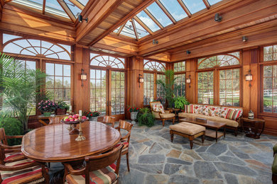 Cette photo montre un porche d'entrée de maison chic avec des pavés en pierre naturelle, une extension de toiture et tous types de couvertures.