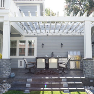 Idee per un portico vittoriano di medie dimensioni e dietro casa con lastre di cemento e una pergola