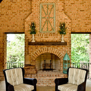 Idee per un grande patio o portico chic dietro casa con un focolare, pavimentazioni in pietra naturale e un tetto a sbalzo