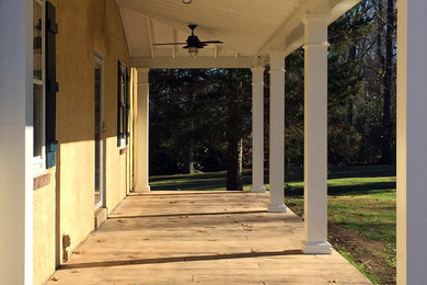 Elegant stamped concrete porch photo in Philadelphia with a roof extension