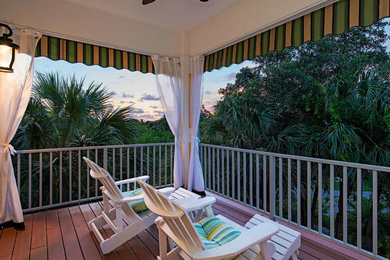 This is an example of a coastal porch design in Miami with an awning.