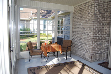 This is an example of a traditional screened-in porch design in Wilmington with a roof extension.