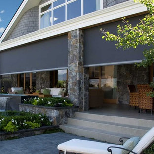 Esempio di un grande portico stile rurale dietro casa con pavimentazioni in cemento, un tetto a sbalzo e un portico chiuso