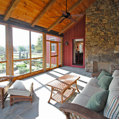 This is an example of a large cottage tile screened-in back porch design in Philadelphia with a roof extension.