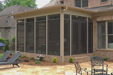 Large classic stamped concrete screened-in back porch idea in Charlotte with a roof extension