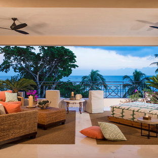 Ispirazione per un grande portico tropicale dietro casa con piastrelle, un tetto a sbalzo e un portico chiuso
