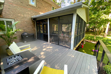 Exemple d'un grand porche d'entrée de maison arrière chic avec une moustiquaire et une extension de toiture.