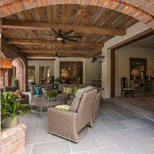 Immagine di un grande portico stile rurale dietro casa con un tetto a sbalzo e piastrelle