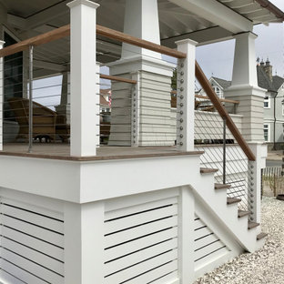 Immagine di un grande portico davanti casa con pedane e un tetto a sbalzo