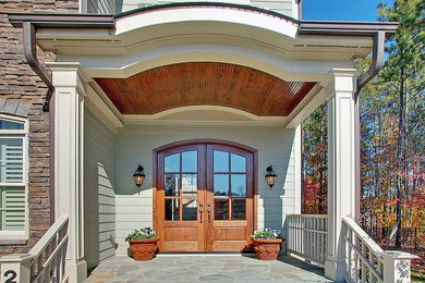 This is an example of a mid-sized traditional front porch design in Raleigh.
