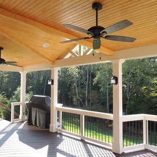 Idee per un grande portico american style dietro casa con pedane e un tetto a sbalzo