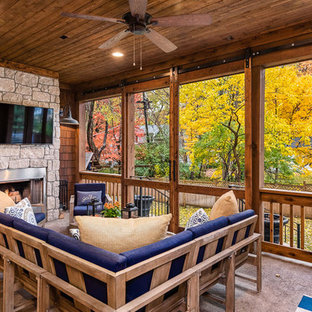Ispirazione per un portico american style di medie dimensioni e dietro casa con un caminetto e un tetto a sbalzo