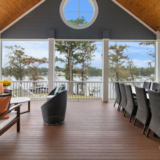 Immagine di un grande portico stile marinaro dietro casa con un portico chiuso, pedane, un tetto a sbalzo e parapetto in legno