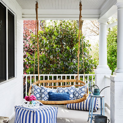This is an example of a coastal front porch design in DC Metro with decking and a roof extension.