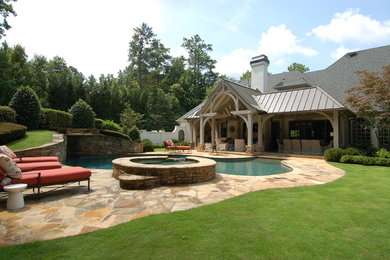 Modelo de terraza clásica renovada grande en patio trasero y anexo de casas con adoquines de piedra natural y fuente