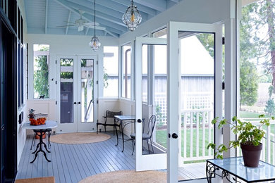 This is an example of a large traditional screened-in back porch design in San Francisco with decking and a roof extension.