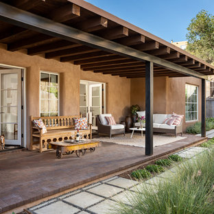 Ispirazione per un portico american style di medie dimensioni e dietro casa con pavimentazioni in mattoni e un tetto a sbalzo
