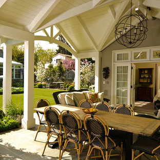 Foto di un portico design di medie dimensioni e dietro casa con un focolare, piastrelle e una pergola