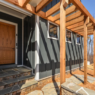 Esempio di un grande portico country davanti casa con pavimentazioni in pietra naturale e una pergola
