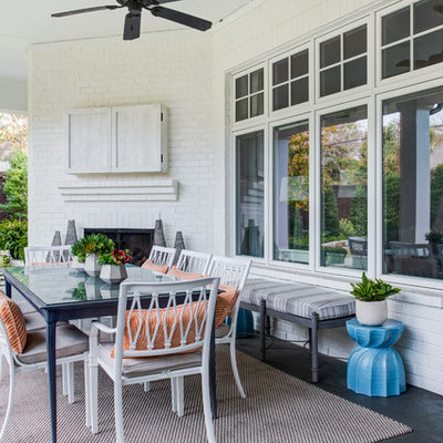 Inspiration for a coastal porch remodel in Dallas with a fireplace and a roof extension
