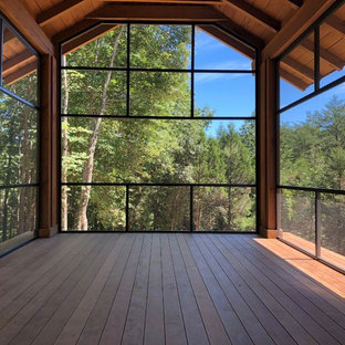 Foto di un portico dietro casa con un tetto a sbalzo, parapetto in metallo, un portico chiuso e pedane
