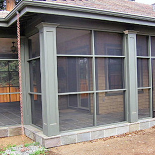 Exemple d'un porche arrière chic de taille moyenne avec une moustiquaire, des pavés en pierre naturelle et une extension de toiture.