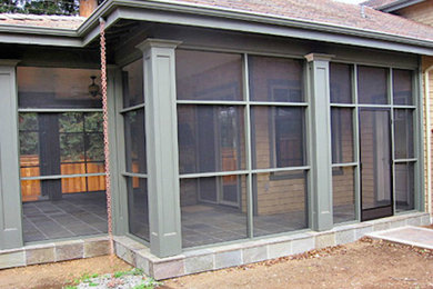 Ejemplo de porche cerrado clásico de tamaño medio en patio trasero y anexo de casas con adoquines de piedra natural
