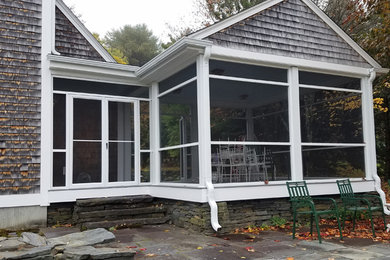 Mid-sized elegant stone screened-in back porch photo in Other with a roof extension