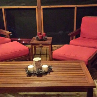 Esempio di un patio o portico american style dietro casa con un portico chiuso, pedane e un tetto a sbalzo