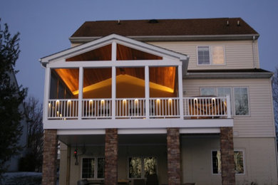 Mid-sized trendy screened-in back porch idea in Baltimore with decking and a roof extension