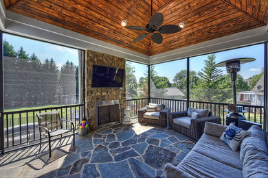 Mid-sized mountain style stone screened-in back porch photo in Other with a roof extension