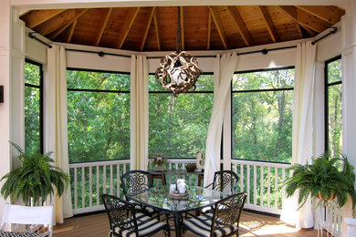 This is an example of a traditional screened-in porch design in Chicago with decking and a roof extension.