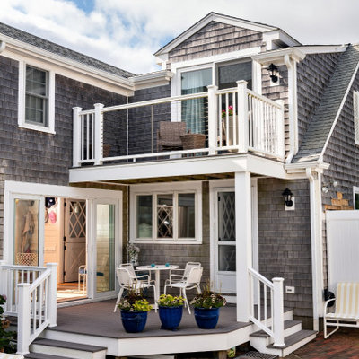 This is an example of a mid-sized coastal brick back porch design in Boston with a roof extension.