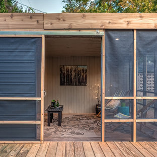 Immagine di un portico rustico dietro casa con un portico chiuso, pedane e un tetto a sbalzo