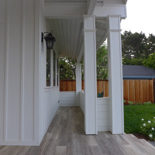 Idee per un ampio portico country davanti casa con pavimentazioni in mattoni e un tetto a sbalzo