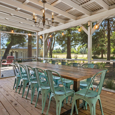 This is an example of a cottage screened-in back porch design in San Francisco with decking and a roof extension.