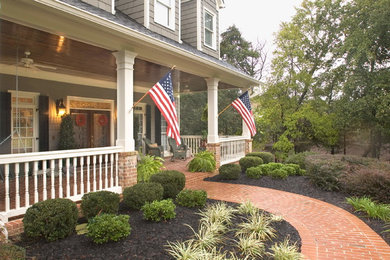 Large elegant brick front porch photo in Atlanta with a roof extension