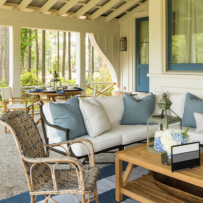 This is an example of a coastal porch design in Charlotte with a roof extension.